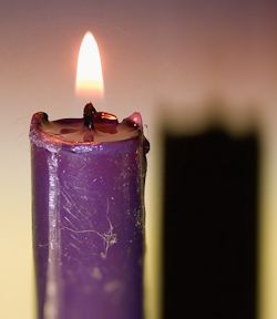 Top and flame of a purple Advent candle