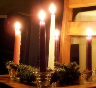 Advent wreath lit and sitting on a wooden chair